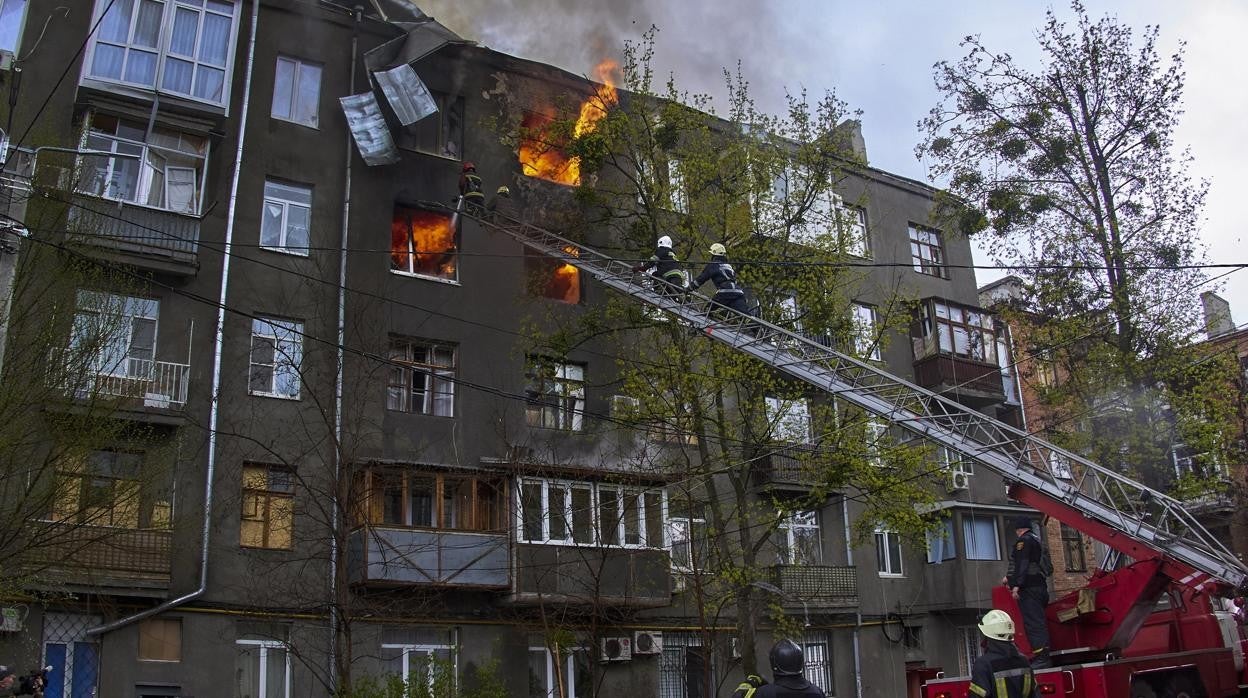 Los bomberos intentan apagar las llamas en un bloque de pisos de Járkov tras un bombardeo ruso