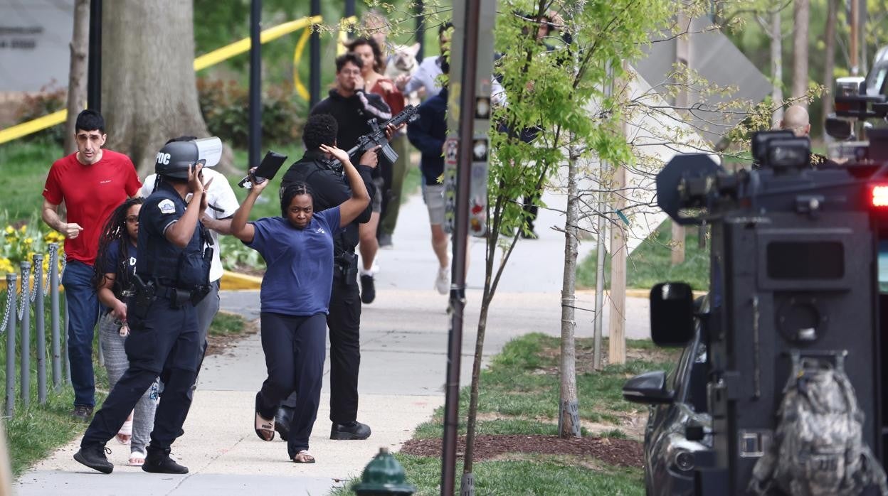 Un ageante de policía escolta a los transeúntes durante el tiroteo en Washington D. C.