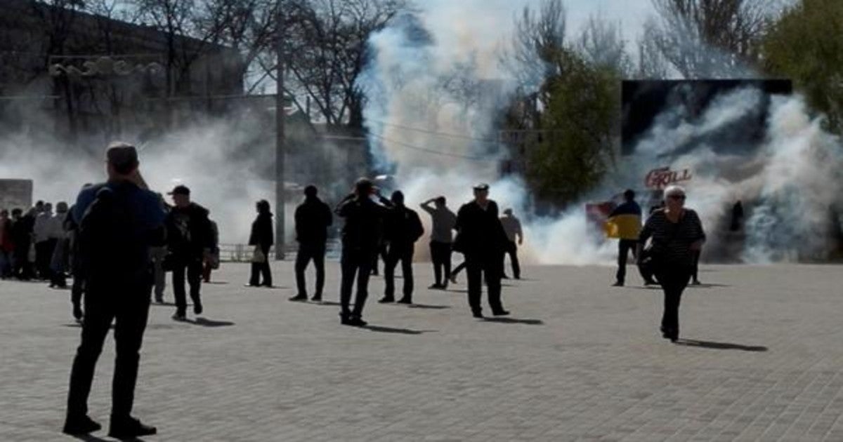 Personas huyen mientras se disparan gases lacrimógenos durante una protesta, en medio de la invasión rusa de Ucrania, en la Plaza de la Libertad en Jersón