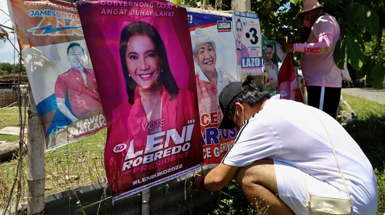 Partidarios de la vicepresidenta Leni Robredo, principal rival de Bongbong Marcos, hacen campaña repartiendo folletos y colocando carteles