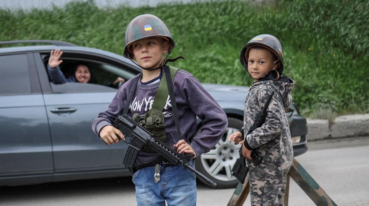 Niños ucranianos juegan a la guerra cerca del liberado pueblo de Stoyanka, en la región de Kiev