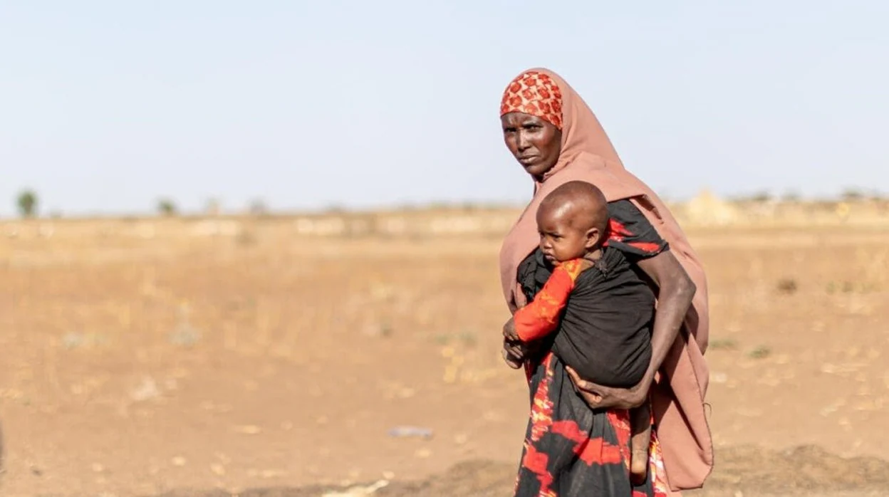 Una madre camina con su hijo en brazos a través del árido paisaje de la región somalí de Etiopía, donde miles de familias han sido desplazadas durante una reciente sequía.