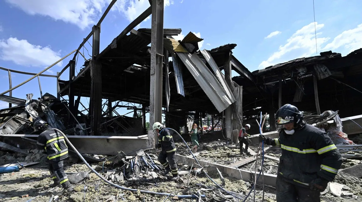 Bomberos recogen los escombros tras el ataque de un misil ruso al centro comercial de Kremenchuk