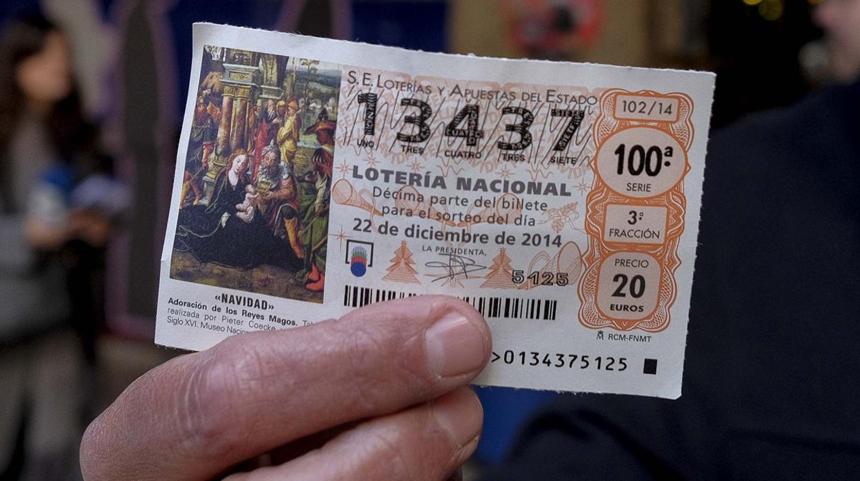 Un empleado del museo de cera de Madrid muestra un boleto de primer premio en la Lotería de Navidad de España en 2014