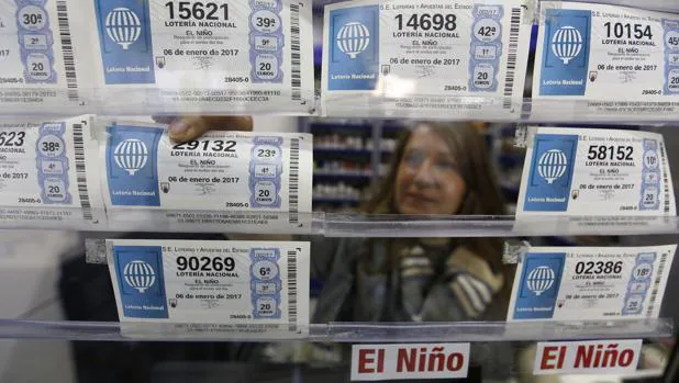 Una lotera coloca boletos de la Lotería del Niño en su administración en Córodoba