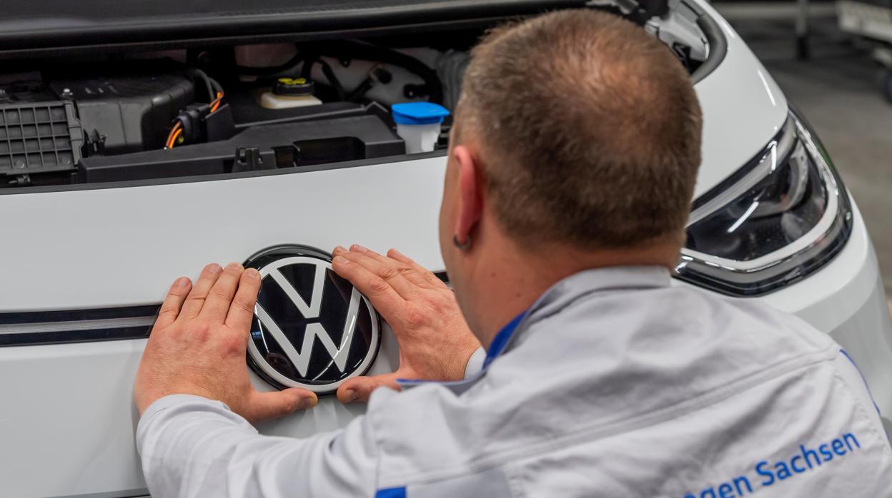 Un operario de Volkswagen coloca un emblema de la marca en una unidad del nuevo ID.3