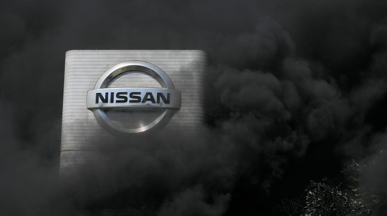 La señalización de la factoría de Nissan en Barcelona, rodeada por el humo tras la quema de neumáticos por parte de los trabajadores