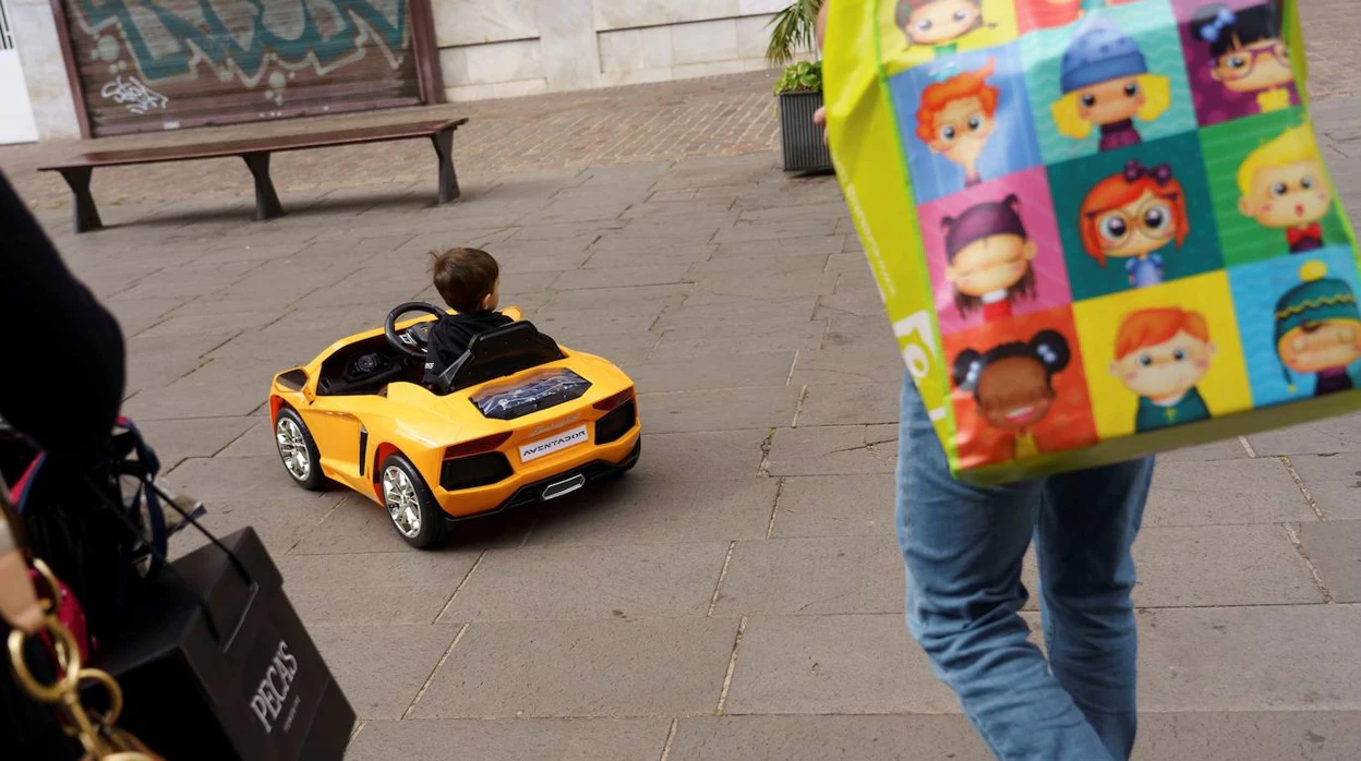 Un niño juega, junto a sus padres, con el coche que le han dejado Sus Majestades Los Reyes Magos, por una de las calles de Santa Cruz de Tenerife