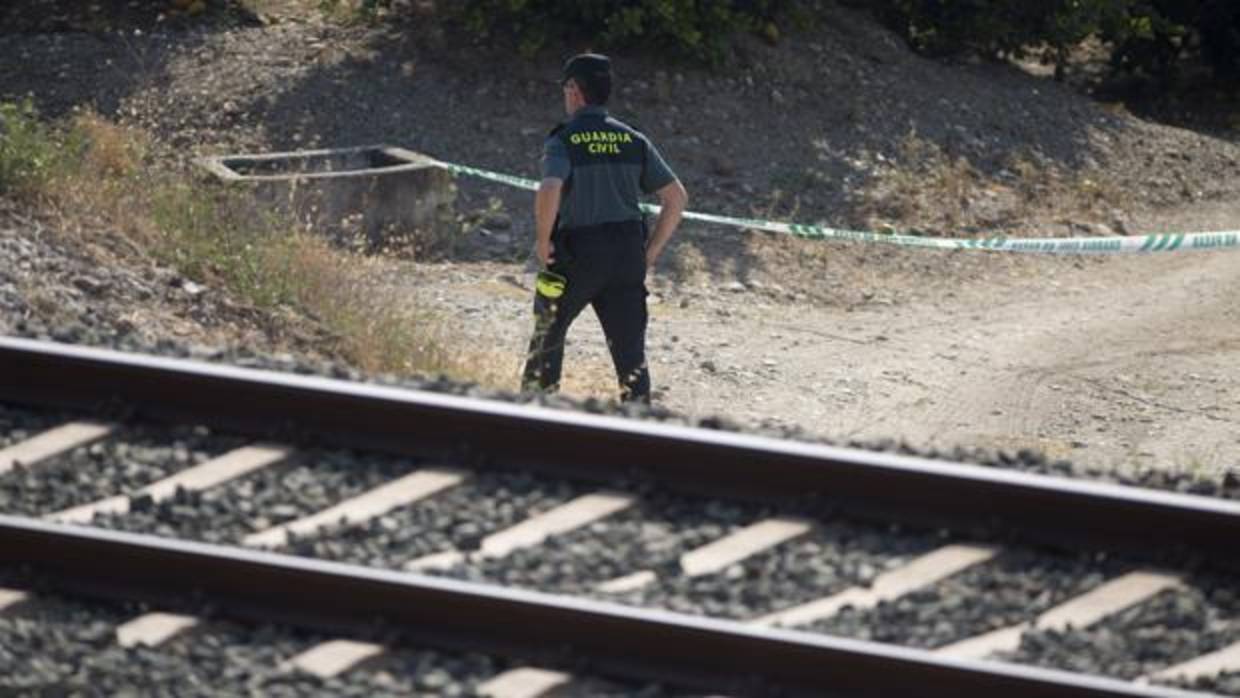 Un guardia civil inspecciona la zona acotada de la vía férrea donde fue hallada la menor