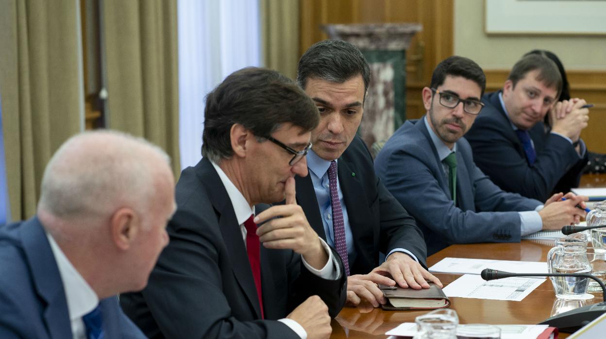 El presidente del Gobierno, Pedro Sánchez (d), preside el comité de Evaluación y Seguimiento del Coronavirus junto al ministro de Sanidad, Salvador Illa (i), en el Ministerio de Sanidad, en Madrid, este miércoles