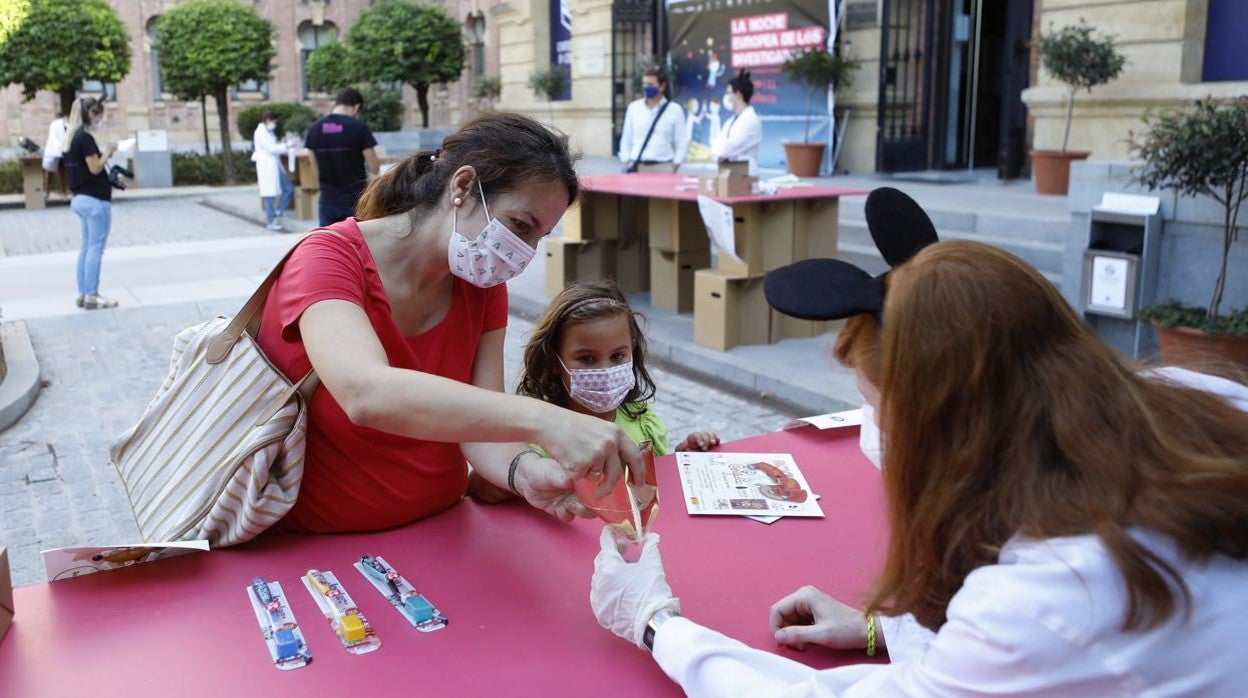 Una niña, ayer donando sus dientes de leche a investigadores de la UCO, caracterizados como el Ratón Pérez