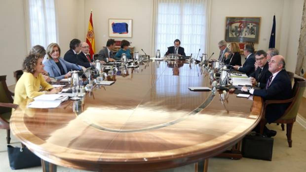 El presidente del Gobierno, Mariano Rajoy (c), junto a sus ministros