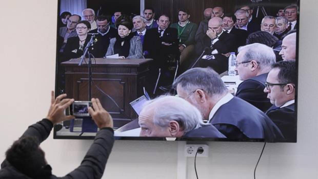 Un periodista fotografía el monitor de la sala de prensa instalada en la Audiencia de Sevilla