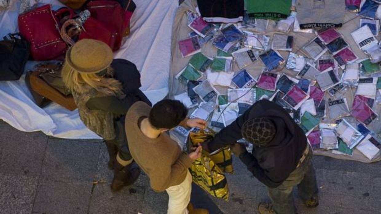 Imagen de un vendedor ambulante, con su mercancía expuesta en mantas