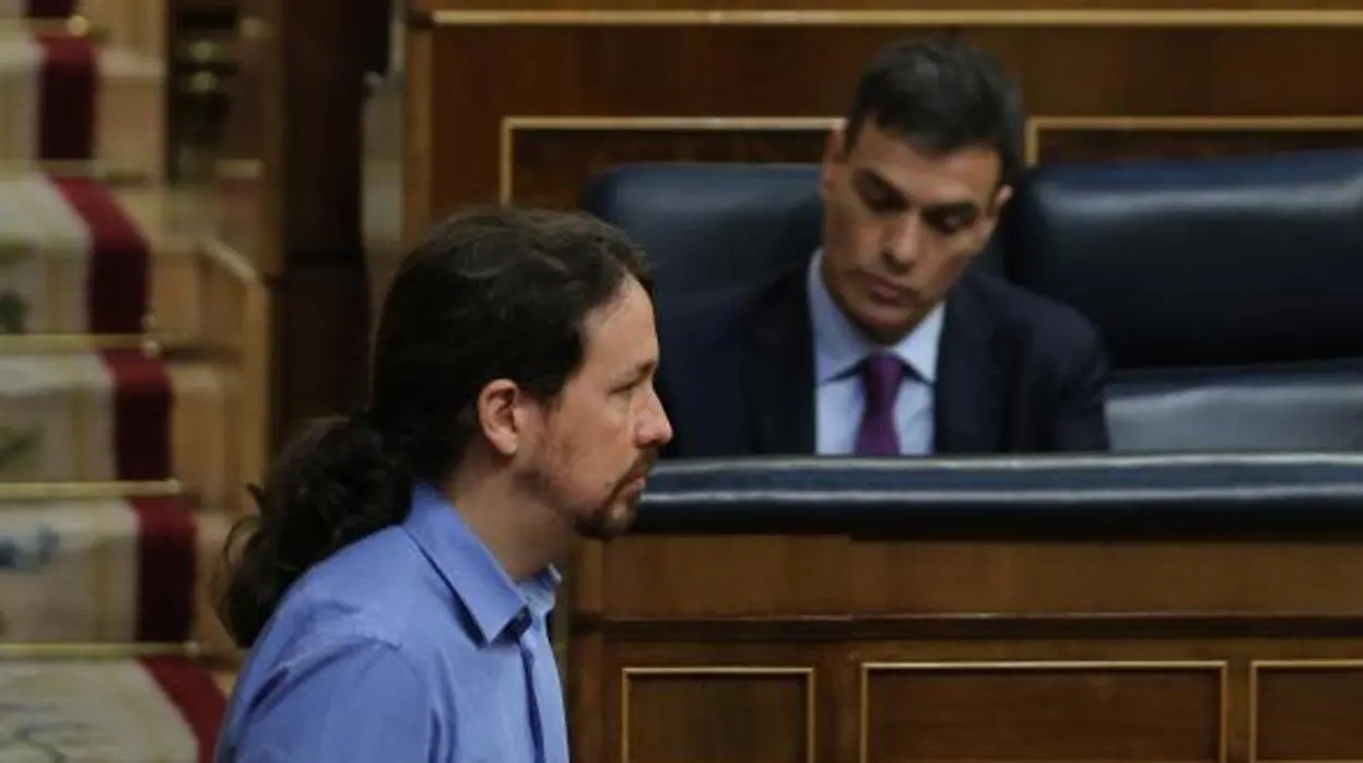En primer término Pablo Iglesias, líder de Podemos, y al fondo Pedro Sánchez, presidente del Gobierno