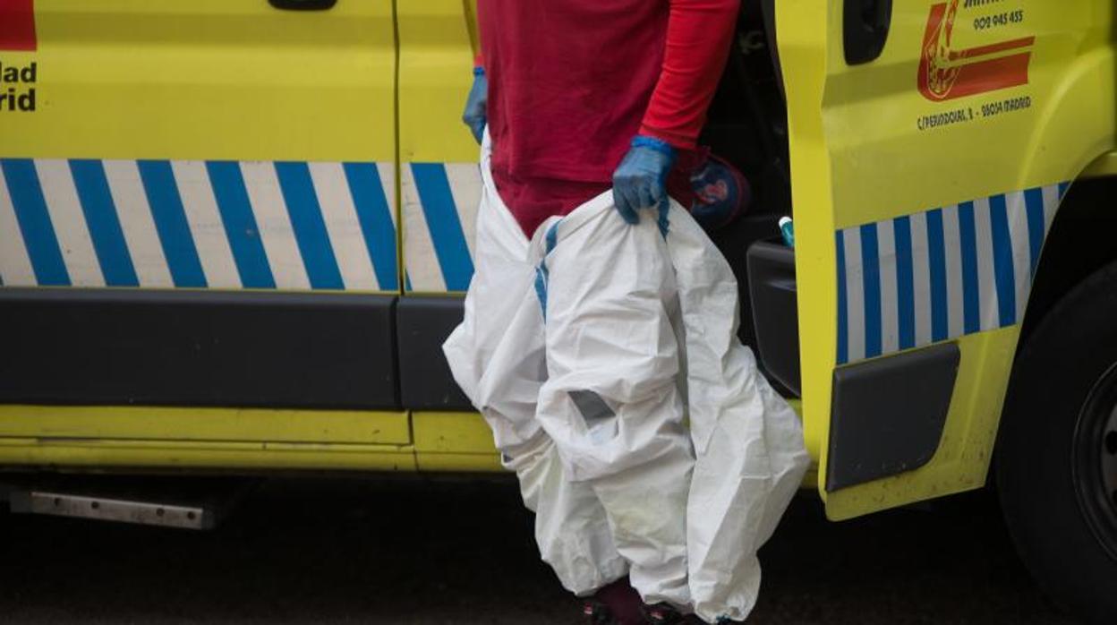 Un miembro de ambulancias se coloca el traje EPI durante la pandemia de Covid-19