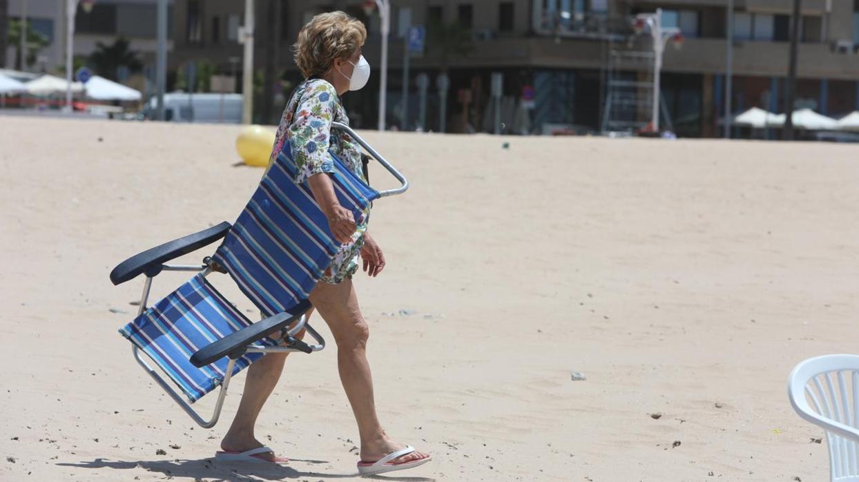 Una señora en la playa de Cádiz tras imponerse el uso obligatorio de la mascarilla en Andalucía.