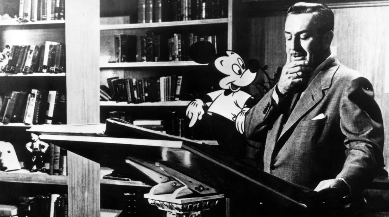 Walt Disney posando con una animación de Mickey Mouse en un estudio de doblaje