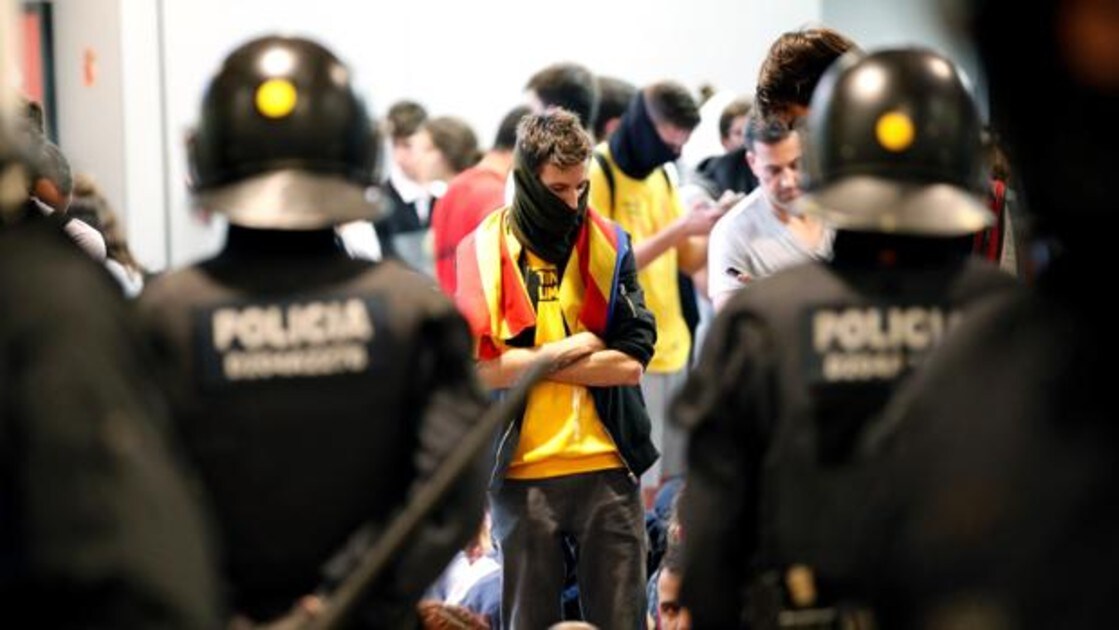 Agentes de los Mossos d'Esquadra controlan a los independentistas que se han concentrado este lunes en el Aeropuerto de El Prat para mostrar su rechazo a la condena del Tribunal Supremo