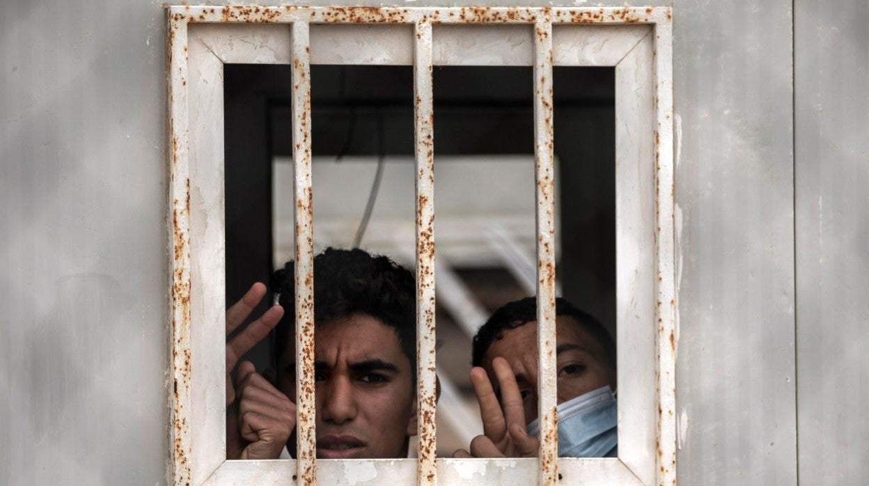 Dos menores saludan por una ventana del albergue de Piniers, donde han sido trasladados algunos de los 850 menores inmigrantes que permanecen en la ciudad española de Ceuta