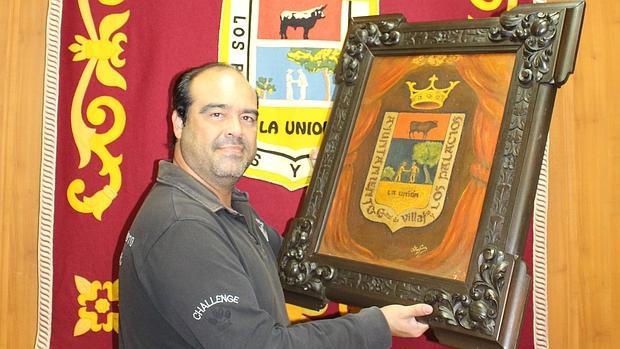Mayo muestra los dos escudos que lucen hoy en el Ayuntamiento