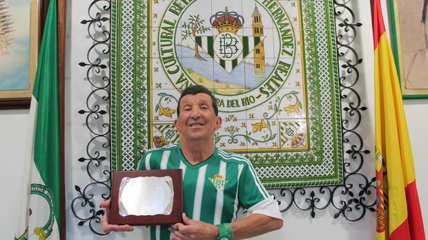 Juan Mendoza enseñando la placa que recibió en su homenaje en la peña bética de Lora