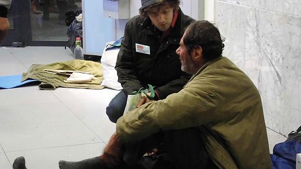 Un voluntario conversa con una persona sin hogar