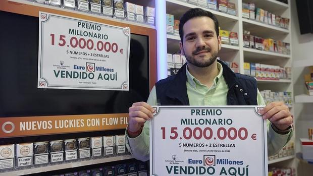 José Luis López, el joven propietario de la Administración de la calle Sagasta, muestra el cartel con el premio.