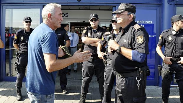 Diego Cañamero conversa con agentes de la Policía Nacional tras el robo de material escolar perpetrado por el SAT