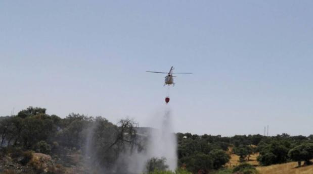 Un helicóperto apagando las llamas en el incendio