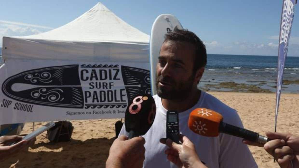 Moisés Carmona, junto al stand de Cádiz Paddle Surf en la playa de La Caleta.