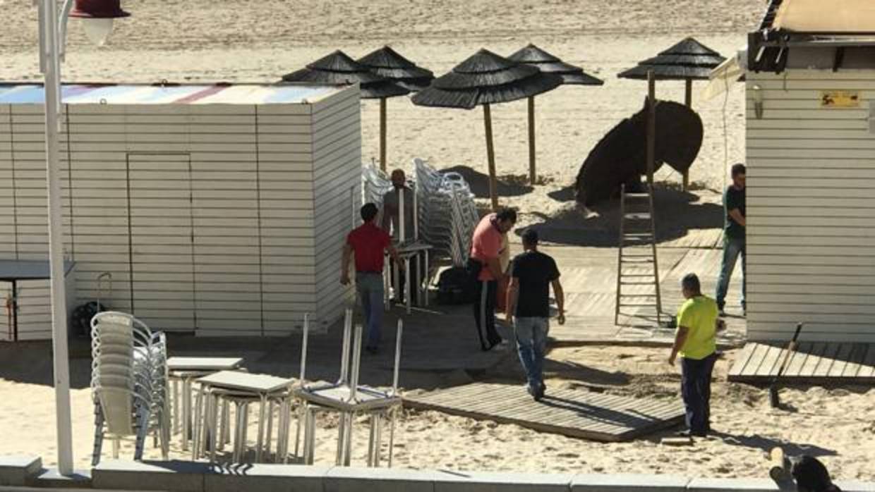 Los operarios desmontan las terrazas de uno de los chiringuitos de la playa Victoria