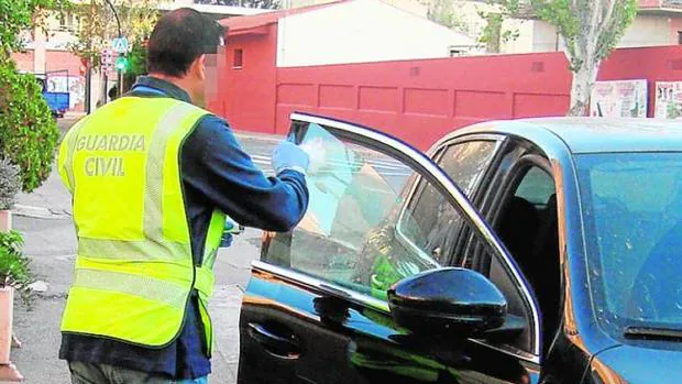 Un agente de la Guardia Civil inspecciona un vehículo