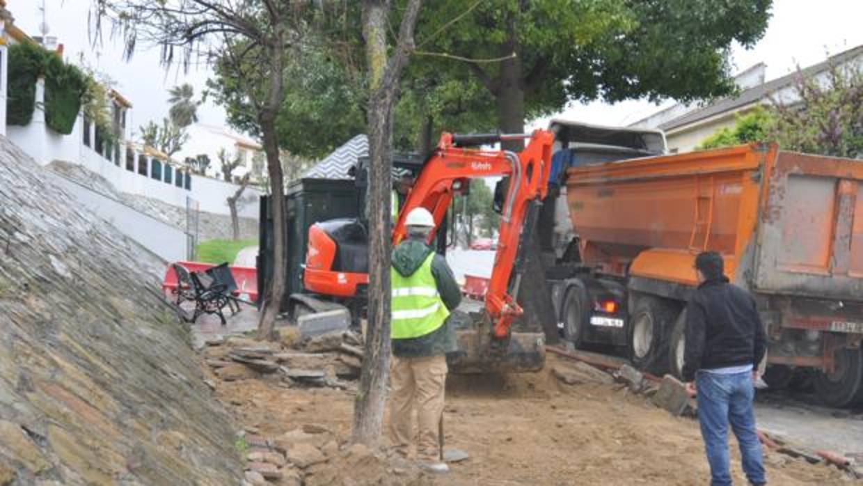 Operarios trabajan sobre el acerado para construir el carril bici