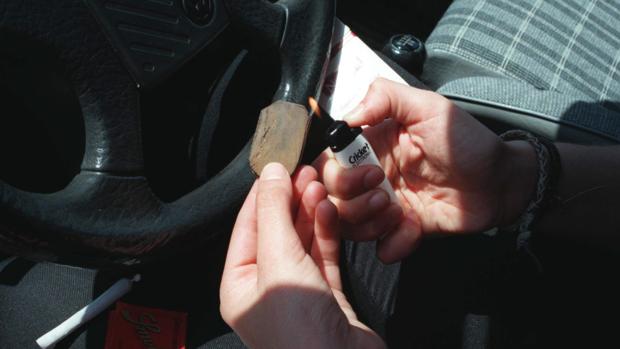 Un joven quema resina de hachís para liarse un porro