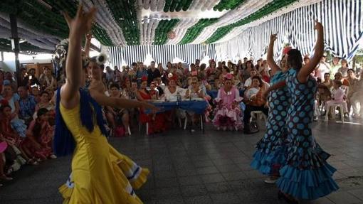 Personas bailando sevillanas en una caseta