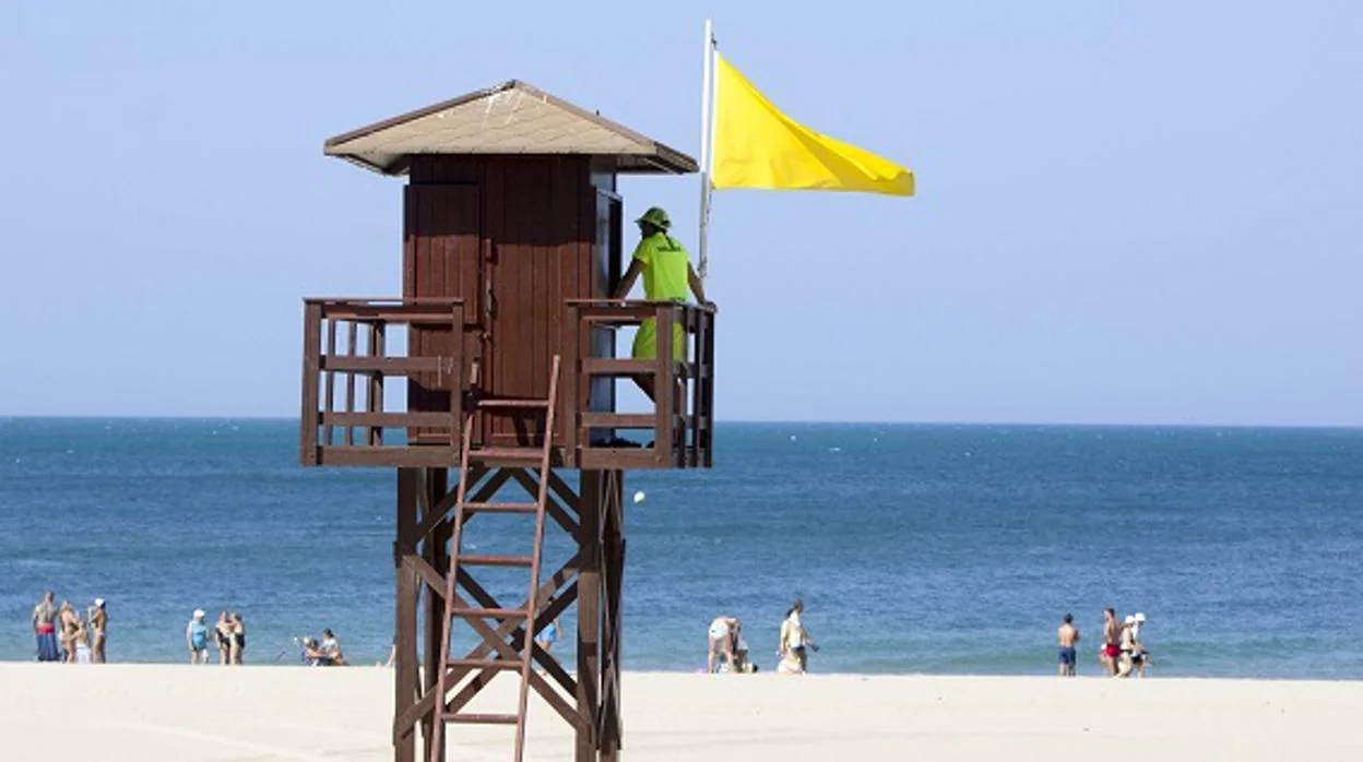 Playa gaditana con bandera amarilla que indica que el baño está permitido con precaución
