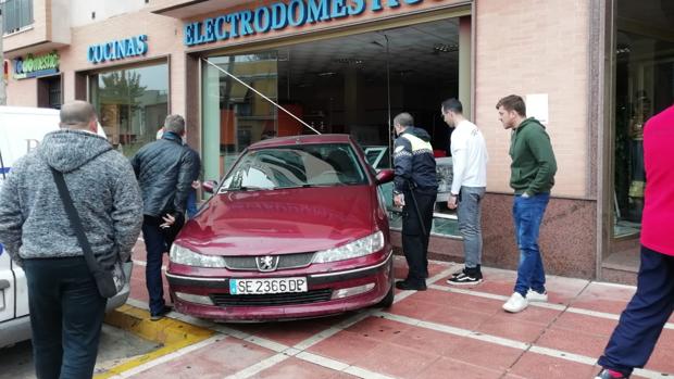 Un coche se estampa contra un escaparate tras dejarlo su dueño aparcado sin freno en Dos Hermanas