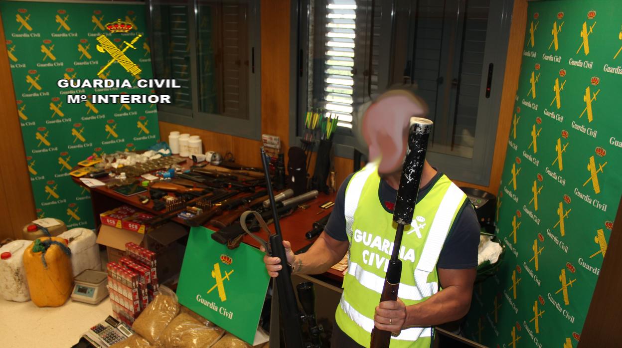 Un agente de la Guardia Civil ante el arsenal incautado tras desarticular una red criminal dedicada al robo de armas de fuego