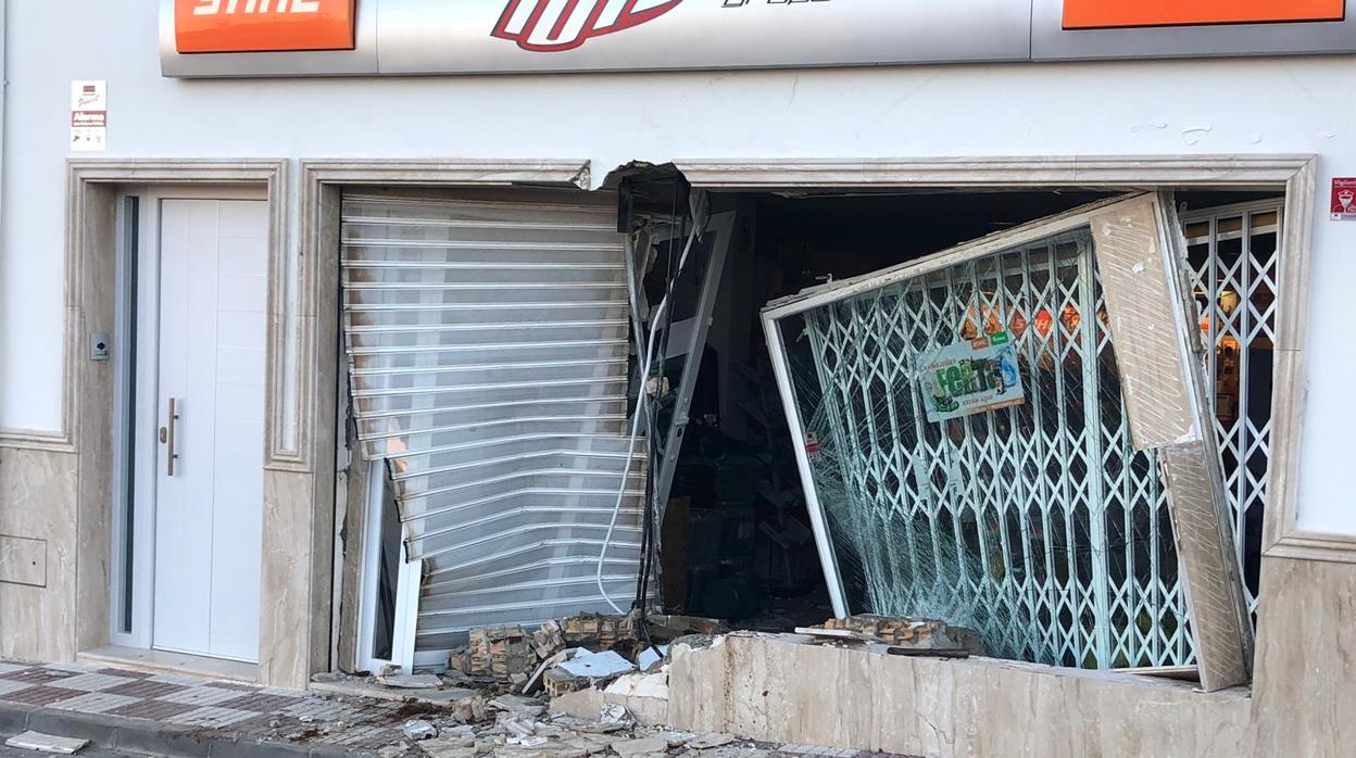 Estado en el que quedaron el escaparate y la puerta de entrada de la tienda alunizada en Herrera