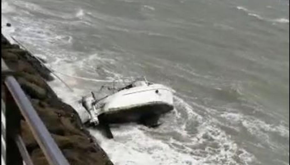 Un velero, a merced del temporal en la Avenida de la Bahía en Cádiz