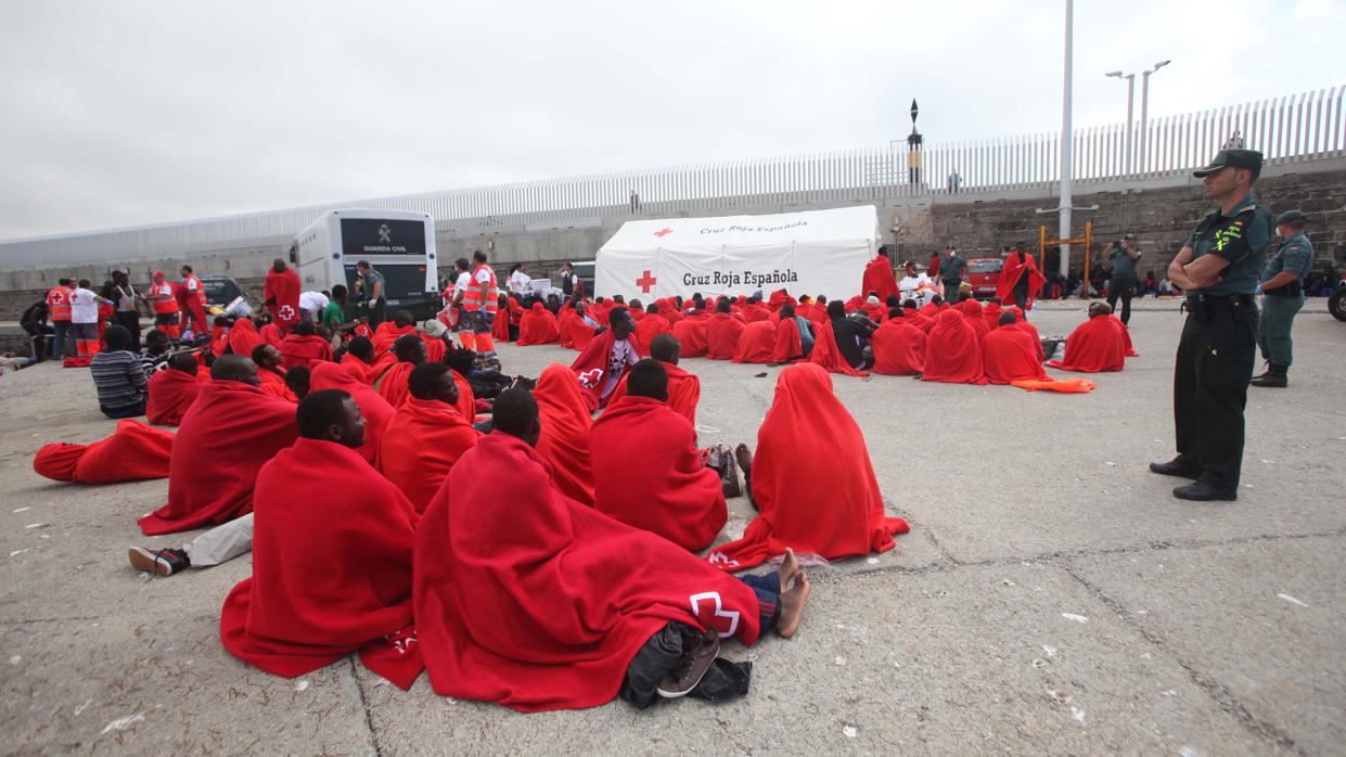 Un grupo de inmigrantes en el puerto de Tarifa, asistidos por Cruz Roja.