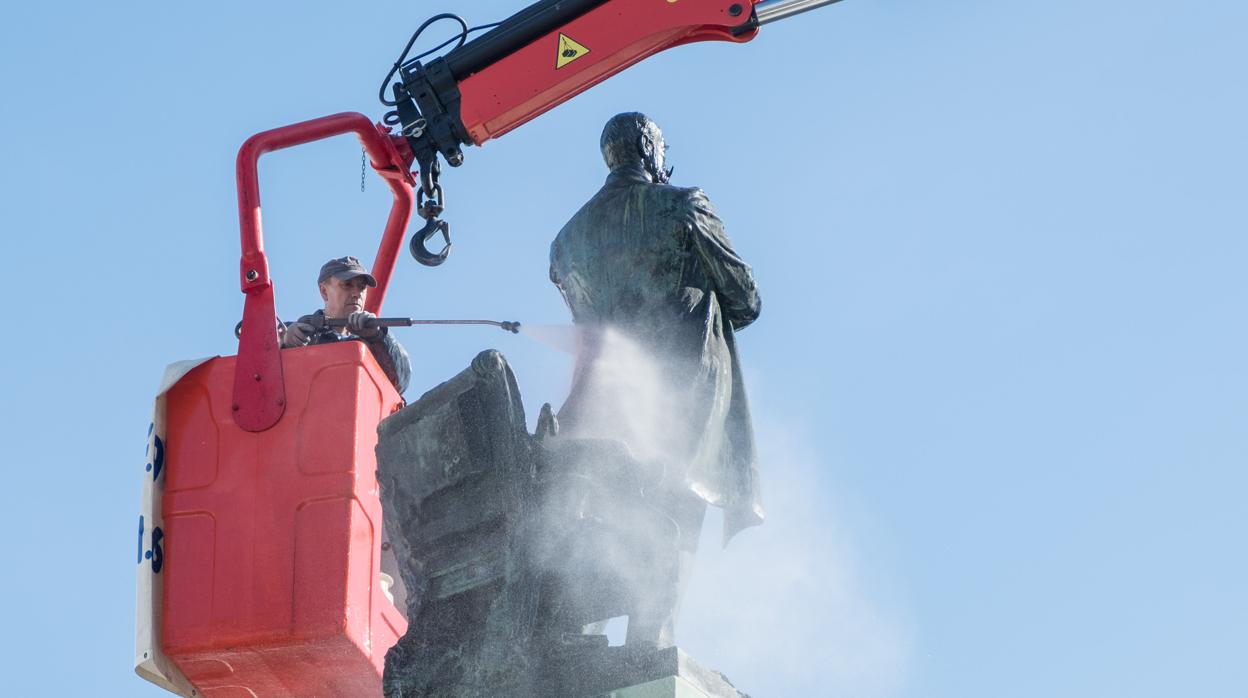 Los operarios limpian la estatua de Moret, sita en la plaza de San Juan de Dios, delante del Ayuntamiento de Cádiz.