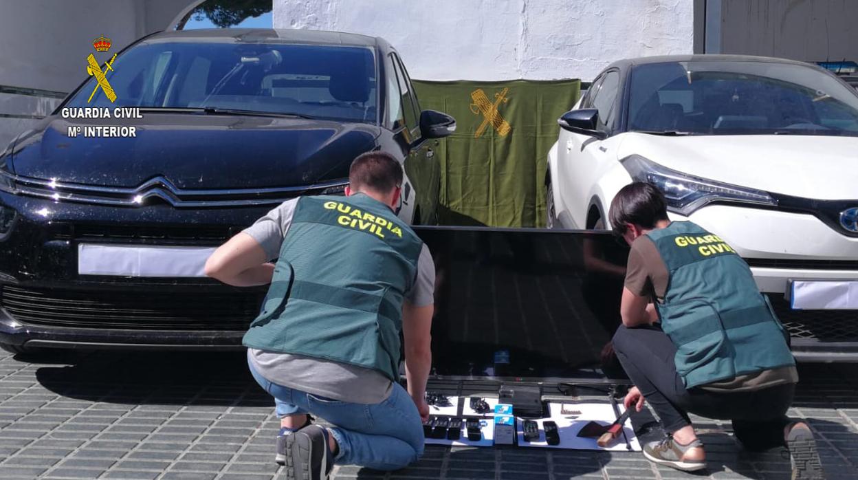 Agentes de la Guardia Civil con los coches y objetos recuperados