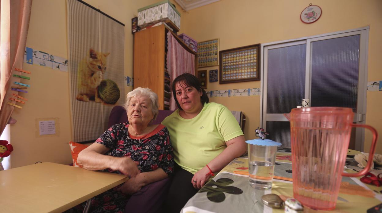 Carmen Otero, de 82 años, junto a una de sus hijas en el piso del que será desalojada el 8 de julio