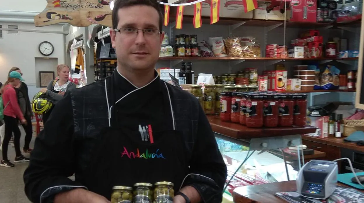 Ángel Silva con varios tarros de aceituna en su negocio de Finlandia