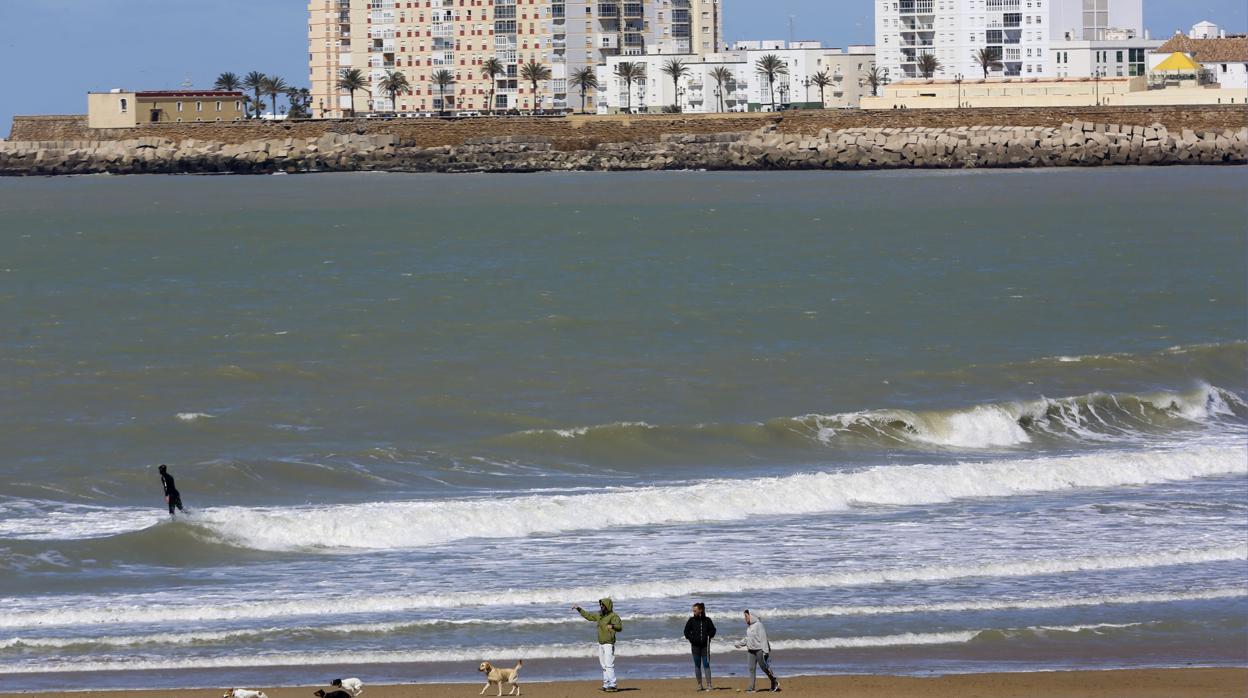 Gente en la playa con abrigos