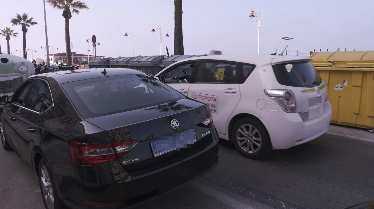 Un coche de Uber junto a un taxi en el Paseo Marítimo.