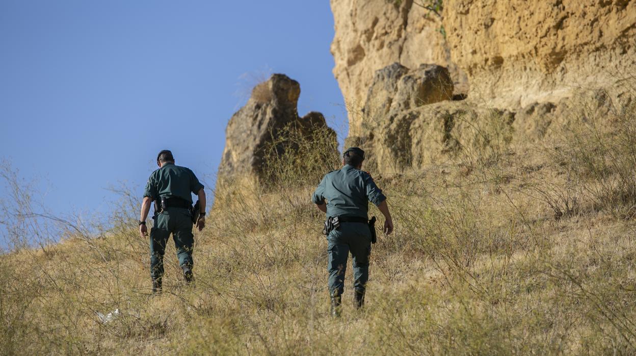 Dos agentes de la Guardia Civil rastrean los alrededores de la vivienda de Mercedes Márquez