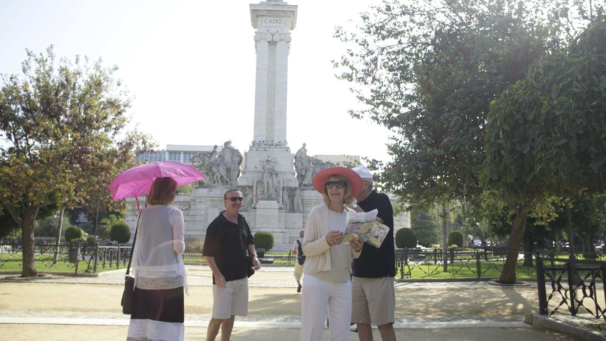 Un grupo de turistas, ante el monumento a la Constitución de 1812, en la plaza de España